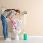 Woman cleaning clogged toilet Staunton, VA