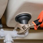 Plumber fixing pipe under sink Harrisonburg, VA